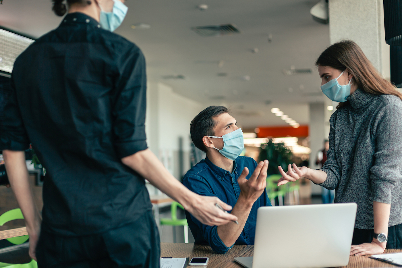 business team in protective masks discussing work issues